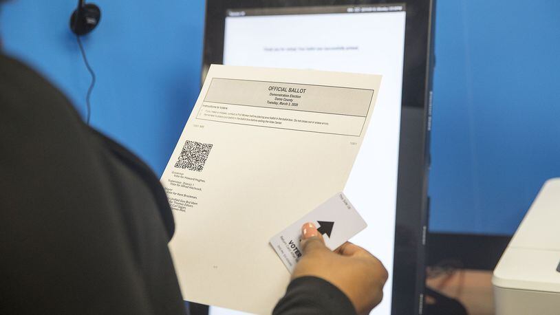 Breanna Thomas, election liaison for the Georgia Secretary of State, looks over her ballot after using the new Georgia voting machine during a demonstration at the James H. “Sloppy” Floyd building in Atlanta, Monday, September 16, 2019. Next to the touchscreen, an HP printer creates a paper ballot. The ballot includes a text listing of voters’ choices along with a bar code that can be read by an optical scanning machine. Voters can review their choices for accuracy and request a new ballot if needed. (Alyssa Pointer/alyssa.pointer@ajc.com)