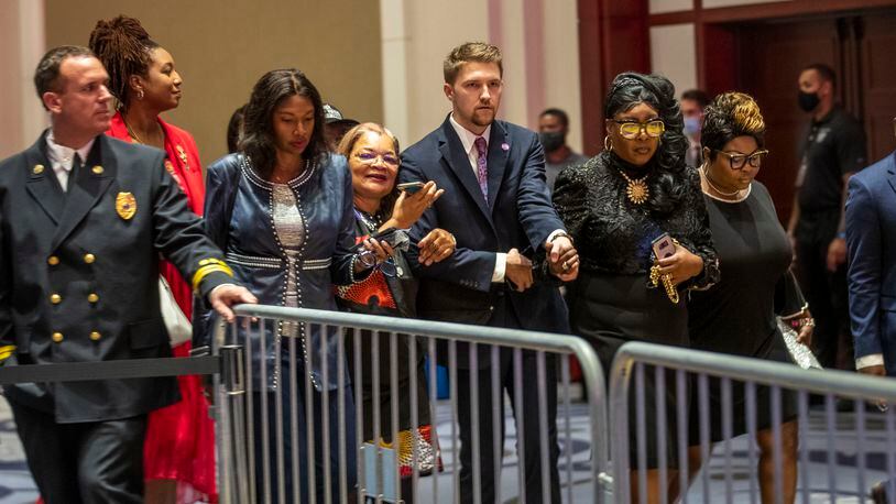 Rochelle Richardson (from right), Lynnette Hardaway (second from right) (known as Diamond and Silk); and Alveda King (fourth from right) are escorted into a ballroom at Cobb Galleria Centre before the start of a Blacks for Trump campaign rally in Atlanta, Friday, Sept. 25, 2020.  (Alyssa Pointer / Alyssa.Pointer@ajc.com)