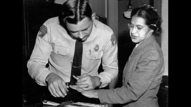 In this Feb. 22, 1956, file photo, Rosa Parks is fingerprinted by police Lt. D.H. Lackey in Montgomery, Alabama, two months after refusing to give up her seat on a bus for a white passenger on Dec. 1, 1955.  (AP Photo/File)