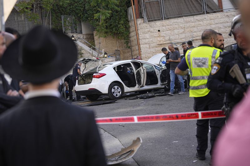 Israeli police investigate the scene of a suspected ramming attack that wounded three people on the eve of the Jewish holiday of Passover, in Jerusalem, Monday, April 22, 2024. Israeli police say a car slammed into pedestrians in Jerusalem on Monday, wounding three people lightly in an apparent attack.(AP Photo/Ohad Zwigenberg)