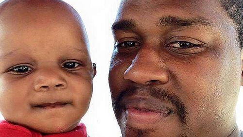JD Ferguson, shown holding his son, Jordan, was shot to death Sunday night while working as a security guard. (Family photo)