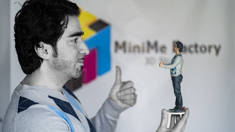 Founder of MiniMe Factory in Alpharetta, Reza Gian Nourali, holds a 9-inch reproduction of himself.