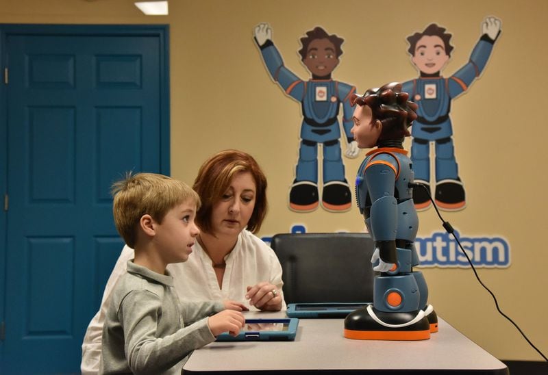 James, 5, watches a therapy robot named Milo as Shelley Margow works with James at Children’s Therapy Works in Roswell recently. Margow has opened her own school catering to children with developmental disabilities. Her school prioritizes these students’ therapeutic and neurological needs, and then incorporates those needs into a personalized education program. Margow uses Milo to teach these kids emotional awareness, and how to interact appropriately with their peers. HYOSUB SHIN / HSHIN@AJC.COM