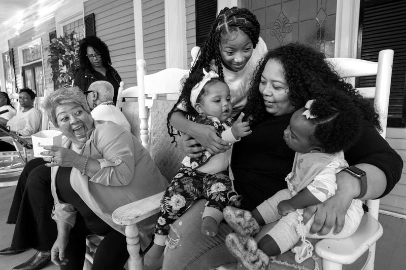 Friends and family of Tommie Lee Dixon Sr. congregate on the front porch of Willie Watkins Funeral Home in the West End after a viewing for Dixon.