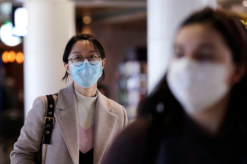 Travelers at Seattle-Tacoma International Airport wear protective face masks Tuesday.