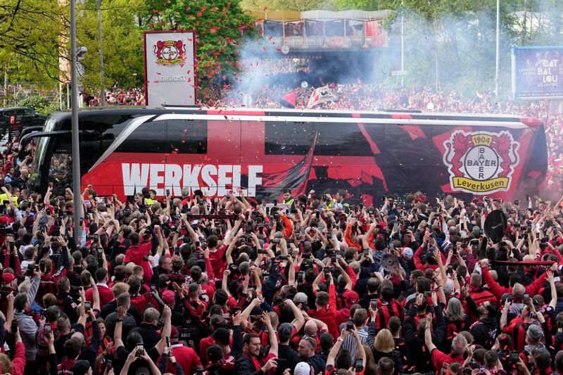 The team bus of Bayer Leverkusen is welcomed by thousands of supporters at the stadium ahead of the German Bundesliga soccer match between Bayer Leverkusen and Werder Bremen in Leverkusen, Germany, Sunday, April 14, 2024. Leverkusen could win the Bundesliga title if they win the match against Bremen.(AP Photo/Martin Meissner)