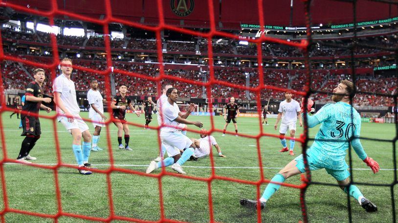 Atlanta United and New England defenders watch a ball that barely misses the top bar on an MLS soccer game at the Mercedes Benz Stadium on May 15, 2009. Miguel Martinez / miguel.martinezjimenez@ajc.com