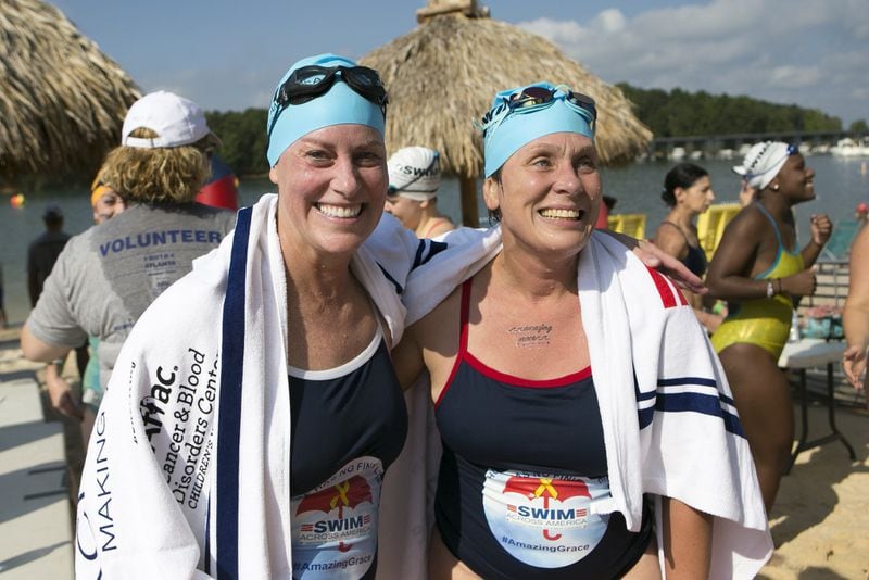Vicki Bunke (left) and Dr. Karen Wasilewski-Masker smile for pictures after completing the 1-mile swim at Swim Across America’s 2018 Atlanta Open Water Swim event at Lake Lanier in Buford. Bunke, 49, trained for three months alongside her daughter Grace’s oncologist, Wasilewski-Masker, 45. Together, they completed the 1-mile swim in honor of Grace. CASEY SYKES / FOR THE ATLANTA JOURNAL-CONSTITUTION