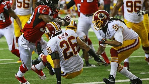 Falcons running back Steven Jackson knocks Redskins cornerback Josh Wilson to the ground on his way into the endzone for a 7-0 lead during 1st half action in a NFL football game on Sunday, Dec. 15, 2013, in Atlanta.
