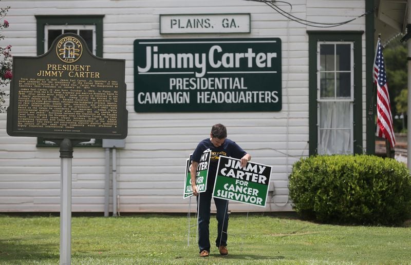 Jill Stuckey places "Jimmy Carter for Cancer Survivor" signs in downtown Plains on Thursday afternoon August 20, 2015 in advance of the President's return to his hometown. Stuckey printed 500 of the signs after seeing one in a Mike Luckovich cartoon drawn just after Carter announced that he had cancer. Ben Gray / bgray@ajc.com