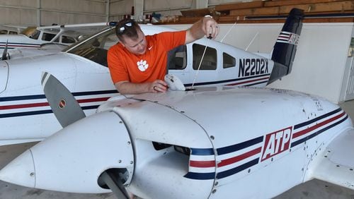 Cass Wood, a student at ATP Flight School, pre-flights an airplane at the Gwinnett County Airport.