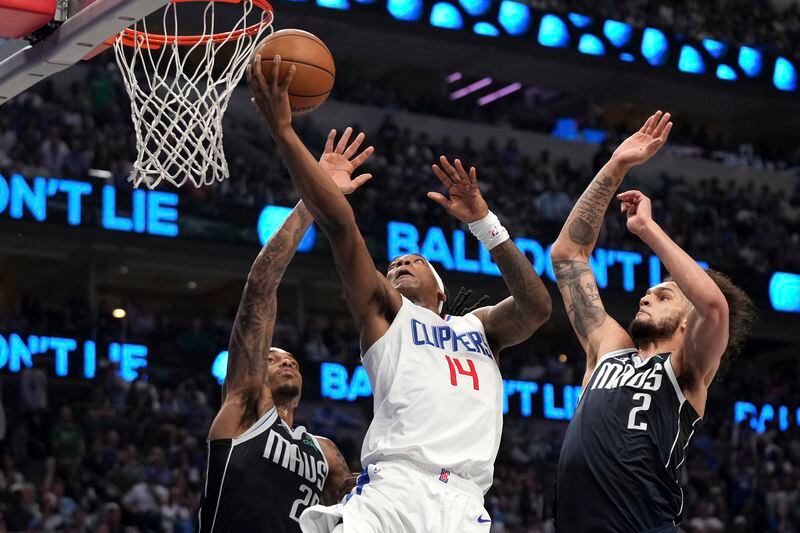 Los Angeles Clippers guard Terance Mann (14) drives to the basket past Dallas Mavericks forward P.J. Washington , left, and center Dereck Lively II (2) during the first half of Game 4 of an NBA basketball first-round playoff series Sunday, April 28, 2024, in Dallas. (AP Photo/Jeffrey McWhorter)