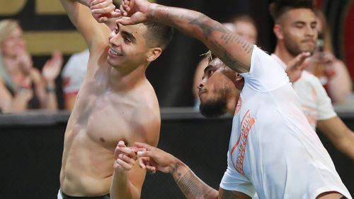 Atlanta United midfielder Miguel Almiron (left) celebrates his goal against Columbus Crew with Josef Martinez for a 3-1 victory during the second half in a MLS soccer match on Sunday, August 19, 2018, in Atlanta. Martinez had an assist on the goal and also tied the MLS season scoring record with his 27th goal during the first half.  Curtis Compton/ccompton@ajc.com