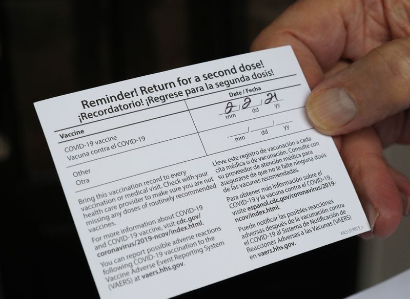 Ron Kurtz shows his vaccination card, with a reminder date for a needed second COVID-19 vaccination. (Curtis Compton / Curtis.Compton@ajc.com)