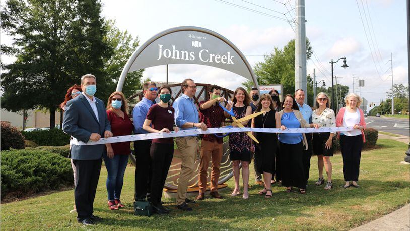 Officials of Johns Creek and its Convention and Visitors Bureau dedicate the city's first gateway marker, on Kimball Bridge Road, in September 2020.  File photo.