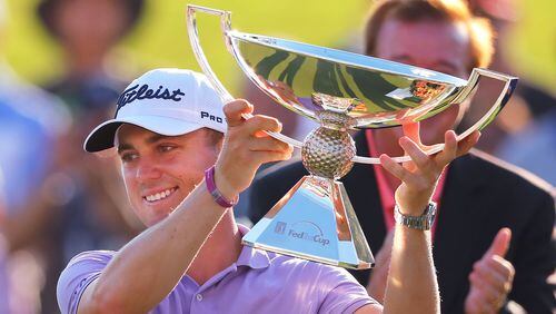 Justin Thomas is presented the FedEx Cup on the 18th green at the conclusion of the Tour Championship at East Lake Golf Club on Sunday, Sept. 24, 2017, in Atlanta.   Curtis Compton/ccompton@ajc.com