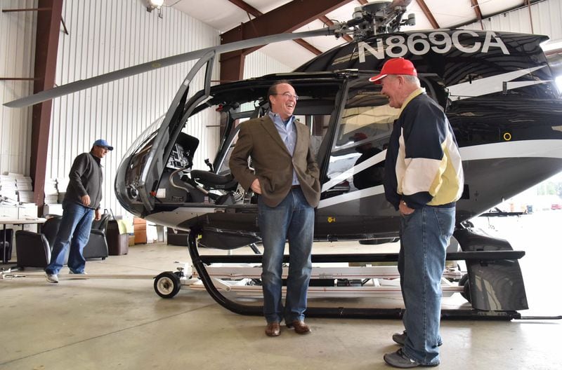 Lance Toland (center) laughs as he shows off a Eurocopter 112 to customers Russ Platt (right) and Maurice Cousineau, who flew from Concord, N.C., to buy the aircraft. The men had gathered at Griffin-Spalding County Airport on Jan. 4. HYOSUB SHIN / HSHIN@AJC.COM