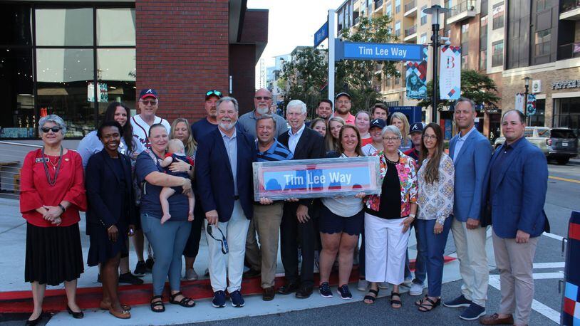 Cobb County officials, Atlanta Braves executives and the family of former Cobb Chairman Tim Lee pose at the dedication of Tim Lee Way in the Battery Atlanta Wednesday.
