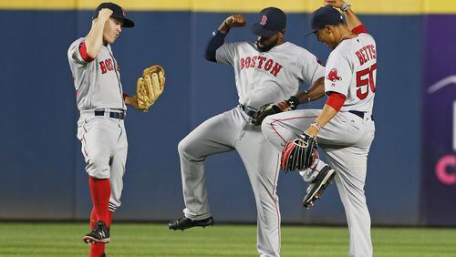 Boston Red Sox outfielders, from left, left fielder Brock Holt (12), center fielder Jackie Bradley Jr. (25) and right fielder Mookie Betts (50) celebrate after defeating the Atlanta Braves, 1-0, in a baseball game Monday, April 25, 2016, in Atlanta. Bradley scored the game's only run with a solo-home run in the seventh inning. (AP Photo/John Bazemore)