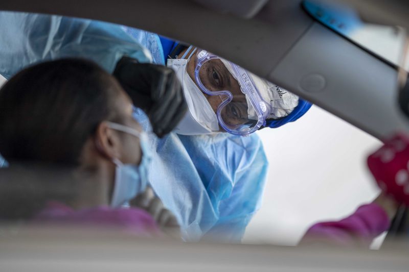A nurse collects a specimen from a patient during a DeKalb County Department of Health drive-thru COVID-19 testing site in Atlanta, Tuesday, Nov. 17, 2020.  This testing site is the busiest site for the DeKalb Department of Health. (Alyssa Pointer / Alyssa.Pointer@ajc.com)