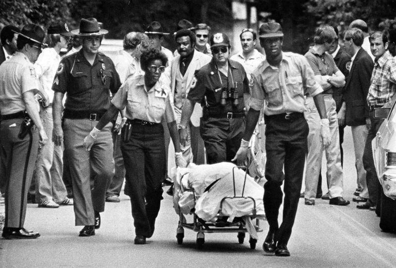 Ambulance attendants move the body of young Nathaniel Cater from the Chattahoochee River in Atlanta before taking it to the Fulton County Medical Examiner’s office. Wayne Williams was charged with murder in the May 1981 death of Cater, who was the latest victim in a string of slayings of young Atlanta blacks. 