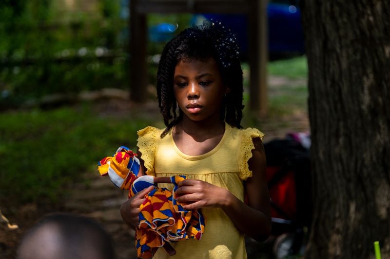 Naomi Steward, 6, a student at Gather Forest School, holds her doll at a park in Atlanta on Thursday, June 30, 2022. (Arvin Temkar / arvin.temkar@ajc.com)
