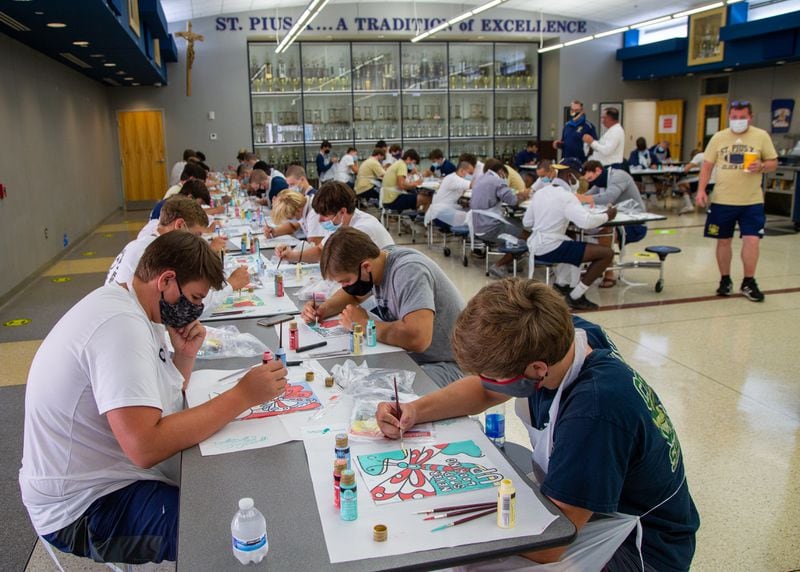 St. Pius X Catholic School football players paint Heart Boards to show their support and appreciation to healthcare worker during the pandemic. PHIL SKINNER FOR THE ATLANTA JOURNAL-CONSTITUTION.