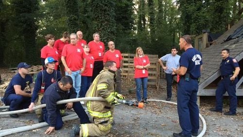 Participants in a past Sandy Springs Citizens Fire Academy learn about hose deployment from members of the Sandy Springs Fire Department. CITY OF SANDY SPRINGS