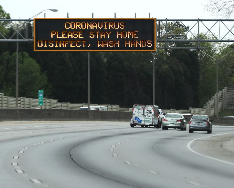 Traffic is light on I-20 West where a DOT sign encourages citizens to stay home, disinfect, and wash hands on Sunday.  Curtis Compton / ccompton@ajc.com