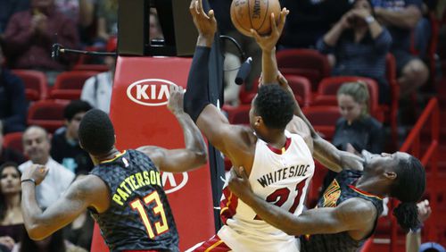 Atlanta Hawks forward Taurean Prince, right, pulls on Miami Heat center Hassan Whiteside (21) as Whiteside goes up for a shot against Prince and guard Lamar Patterson (13) during the second half of an NBA basketball game, Wednesday, Feb. 1, 2017, in Miami. Prince was ejected for pulling Whiteside down and was assessed a flagrant-2. James Johnson retaliated in Whiteside’s defense, and was ejected after getting a technical. The Heat defeated the Hawks 116-93. (AP Photo/Wilfredo Lee)