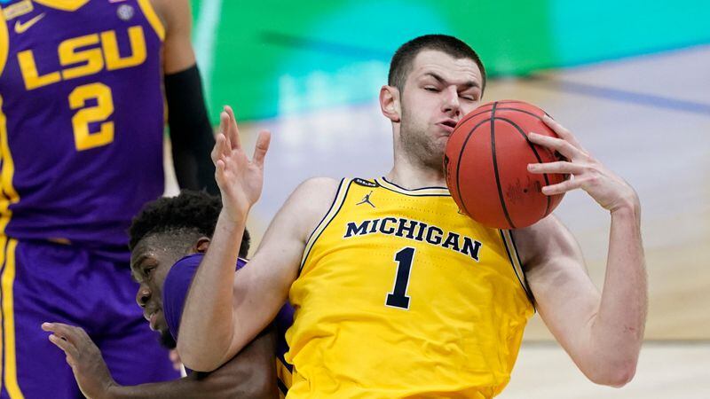 Michigan center Hunter Dickinson (1) grabs a rebound over LSU forward Darius Days, left, during the second half of a second-round game in the NCAA men's college basketball tournament at Lucas Oil Stadium Monday, March 22, 2021, in Indianapolis. (AP Photo/AJ Mast)