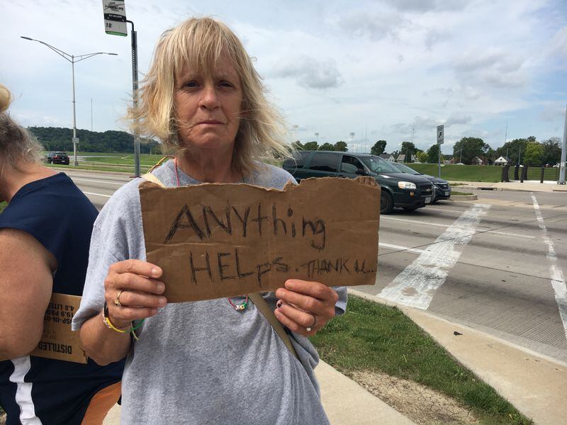 Abigail O’Neil, holding a sign at the intersection of Stewart Street and Patterson Boulevard, pulled up her sleeves to show she has no needle marks. “I’m no drug addict. You’re not going to find one needle mark except where a doctor took blood,” she said.