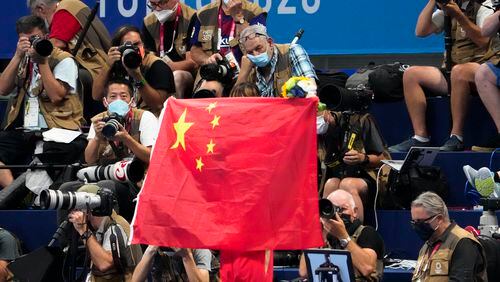 FILE - A Chinese flag is unfurled on the podium of a swimming event final at the 2020 Summer Olympics, on July 29, 2021, in Tokyo, Japan. An Australian newspaper said Saturday, April 20, 2024, 23 Chinese swimmers were cleared to compete at the Tokyo Olympics despite testing positive to doping because world governing bodies agreed with Chinese authorities and ruled that the tests had been contaminated.(AP Photo/Charlie Riedel, File)