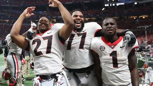 December 2, 2017 Atlanta: Georgia Bulldogs running back Nick Chubb (27), offensive tackle Isaiah Wynn (77), and running back Sony Michel (1) rejoice after the Bulldogs defeated Auburn 28-7 during the SEC Football Championship at Mercedes-Benz Stadium, December 2, 2017, in Atlanta.  Curtis Compton / ccompton@ajc.com