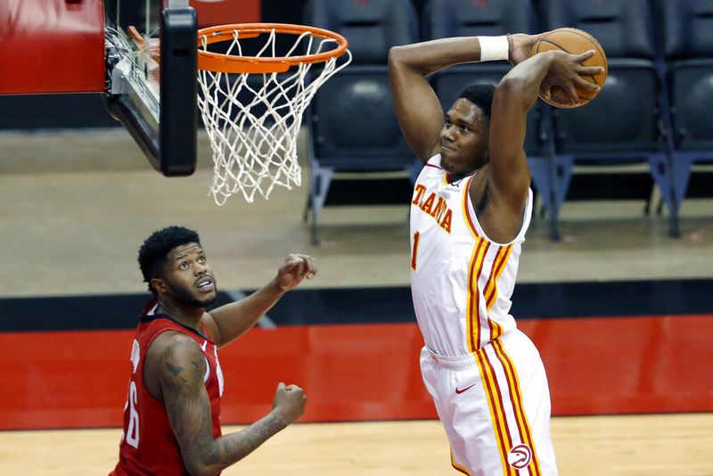 Atlanta Hawks forward Nathan Knight (1) dunks the ball as Houston Rockets center Justin Patton, left, looks on during the first half of an NBA basketball game Tuesday, March 16, 2021, in Houston. (AP Photo/Michael Wyke)