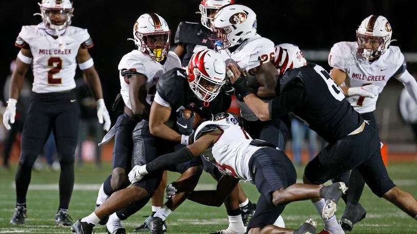 Milton running back Bryce Thornton (7) is stopped by a host of Mill Creek defenders during the first half of their Class 7A semi-final at Lakewood Stadium, Friday, December 2, 2022, in Atlanta.  Jason Getz / Jason.Getz@ajc.com)