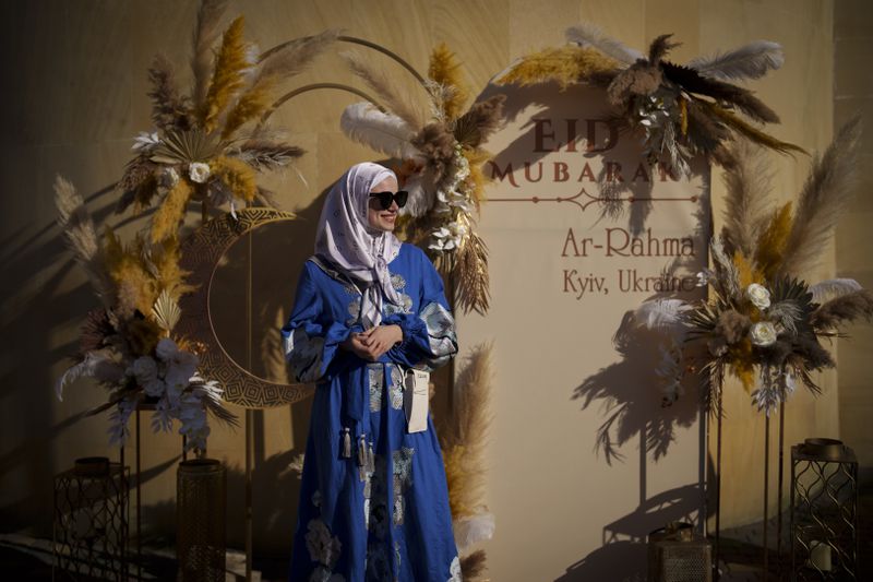 A woman poses for a photograph at the end of Eid al-Fitr prayers in Kyiv, Ukraine, Wednesday, April 10, 2024. Members of the Ukrainian Muslim community joined prayers at the Ar-Rahma Mosque in the Ukrainian capital. Eid al-Fitr marks the end of the holy fasting month of Ramadan. (AP Photo/Vadim Ghirda)