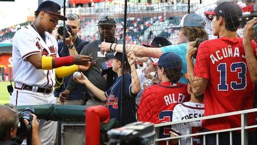 Braves outfielder Ronald Acuna signs autographs for young fans before the April 28, 2022, game against the Chicago Cubs at Truist Park.  (Curtis Compton / Curtis.Compton@ajc.com)