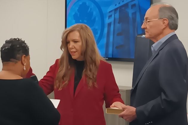 Julie Adams (center) is sworn in as a member of the Fulton County Board of Registration & Elections on Feb. 8, 2024. Clerk of Courts Che' Alexander (left) administers the oath while Mike Heekin, Adams' fellow Republican board member, holds a Bible.