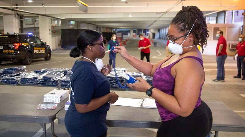 CVS nurses Sharing Neal and Alicia Robinson go through the check-in steps in preparation for the opening of the COVID-19 drive-thru testing center in Atlanta on April 6, 2020. STEVE SCHAEFER / Special to The AJC