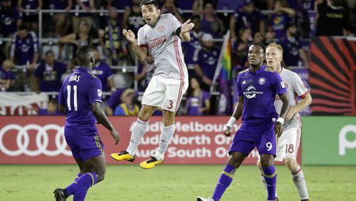 Atlanta United's Michael Parkhurst (3) heads the ball as he gets between Orlando City's Carlos Rivas (11) and Cyle Larin (9) during the second half of an MLS soccer match, Friday, July 21, 2017, in Orlando, Fla. Atlanta United won 1-0. (AP Photo/John Raoux)