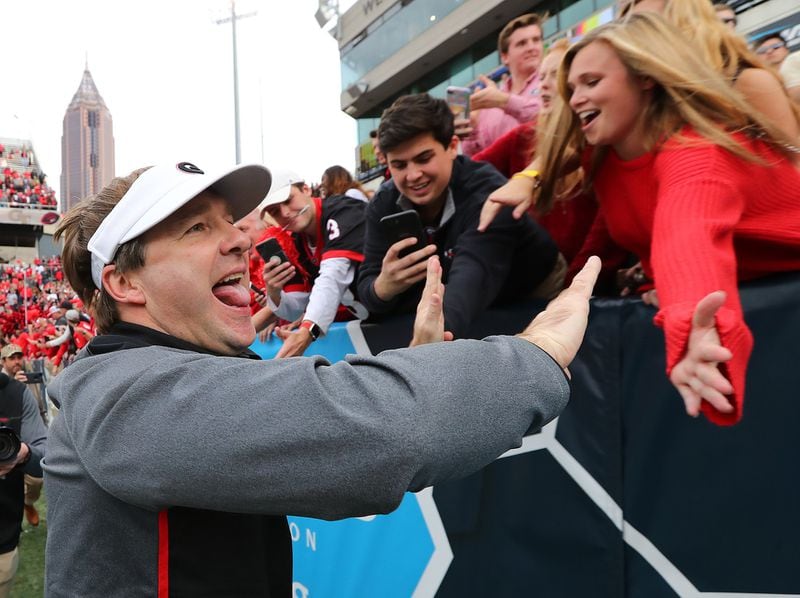 Georgia football head coach Kirby Smart high fives fans after beating Georgia Tech 38-7 in Atlanta. Will fans of UGA and other universities be less willing to buy season tickets if a juicy tax deduction is eliminated? Curtis Compton/ccompton@ajc.com
