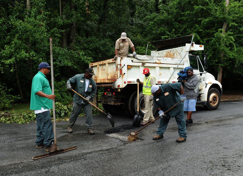 Workers from DeKalb County work on paving over a pothole on Friday, June 13, 2012. JOHNNY CRAWFORD / JCRAWFORD@AJC.COM.
