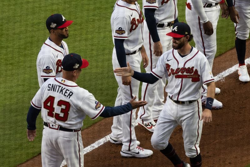 Braves shortstop Dansby Swanson (7) high fives manager Brian Snitker (43) before a game against the Cincinnati Reds at Truist Park on Thursday, April 7, 2022, in Atlanta.  Branden Camp/For the Atlanta Journal-Constitution