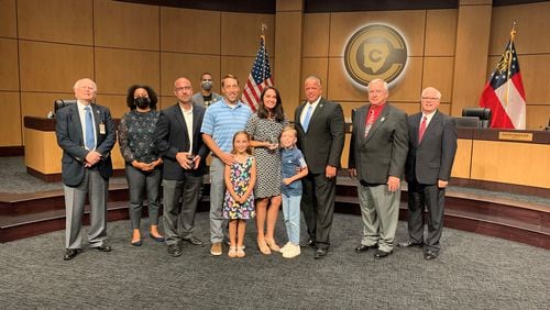 Osborne High School educator Beth Foster, center, was named Cobb County School District's teacher of the year. She was honored by Superintendent Chris Ragsdale and Cobb County School Board members. Credit: Cobb County School District