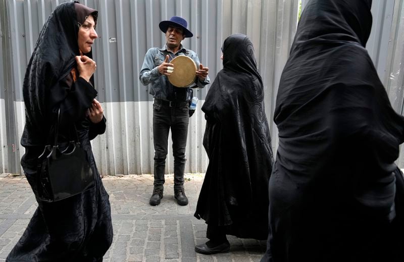 A street musician plays music at the old main bazaar in Tehran, Iran, Tuesday, April 16, 2024. Israel says it is poised to retaliate against Iran, risking further expanding the shadow war between the two foes into a direct conflict after an Iranian attack over the weekend sent hundreds of munitions into Israeli airspace. (AP Photo/Vahid Salemi)