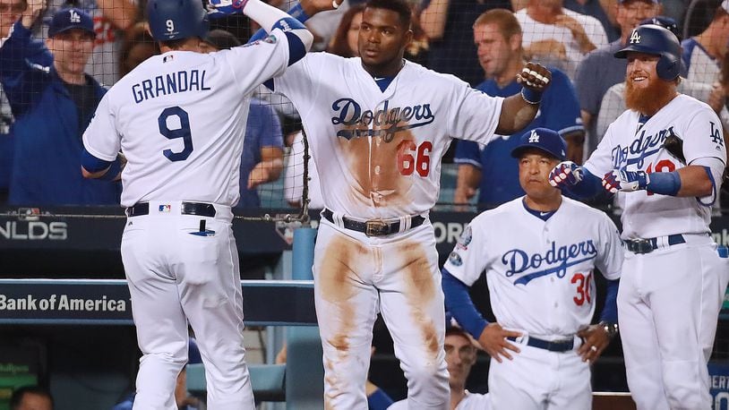 Justin Turner of the Dodgers is greeted by Yasiel Puig after hitting a solo homer for a 3-0 lead over the Braves during the fifth inning in Game 2 of a National League Division Series baseball game Friday, Oct 5, 2018, in Los Angeles. The Dodgers beat the Braves 3-0. Curtis Compton/ccompton@ajc.com