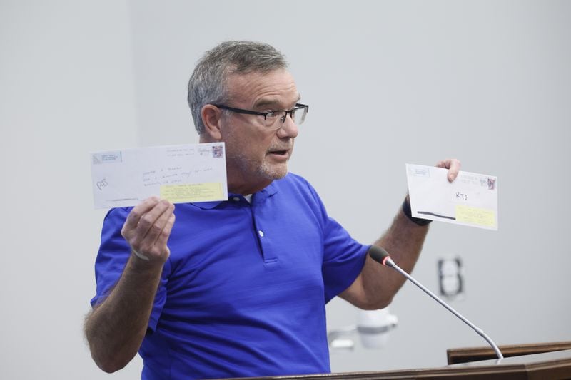 Cobb County resident Eugene Williams holds up envelopes he mailed to addresses that he says are invalid on Monday, October 10, 2022. (Natrice Miller/natrice.miller@ajc.com)  
