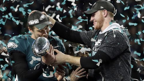 Philadelphia Eagles quarterback Carson Wentz, right, hands the Vincent Lombardi trophy to Nick Foles after winning the NFL Super Bowl 52 football game against the New England Patriots, Sunday, Feb. 4, 2018, in Minneapolis. The Eagles won 41-33. (AP Photo/Frank Franklin II)
