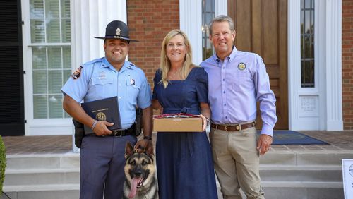 Gov. Brian Kemp and First Lady Marty Kemp pose with Rex, a dog she helped recruit for the state’s K-9 program. File. 